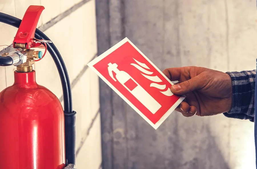 persona revisando la señalización de un extintor